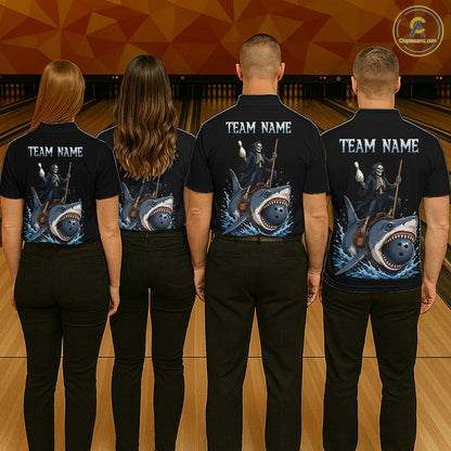 Four people standing in a bowling alley, viewed from behind, wearing matching black short-sleeve polo shirts with a large shark-and-whale graphic on the back and white 'TEAM NAME' text. The shirts also show skeleton divers holding ping-pong paddles.