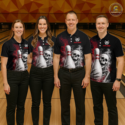 Four people standing together in a bowling alley wearing matching black short-sleeve polo shirts with a large graphic print of a skull and bowling pins, paired with black pants. 