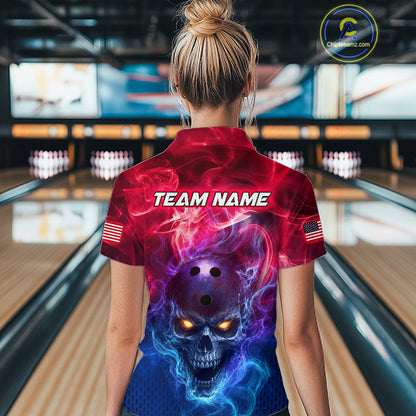 A woman viewed from behind wearing a short-sleeve bowling shirt with a red, purple, and blue skull graphic on the back, standing in a bowling alley. The shirt has 'TEAM NAME' printed across the upper back and small American flag patches on the sleeves.