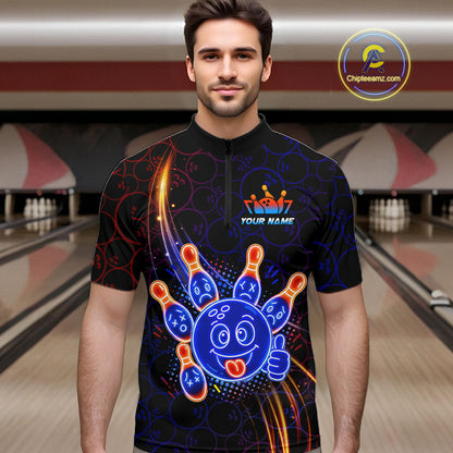 Man standing in a bowling alley wearing a black neon-style bowling quarter zip shirt with a glowing blue cartoon bowling ball mascot, fiery orange pin graphics, and custom name text.