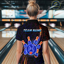Load image into Gallery viewer, Woman standing in a bowling alley wearing a black neon-style bowling quarter zip shirt with a glowing blue cartoon bowling ball mascot, fiery orange pin graphics, and custom team name text.