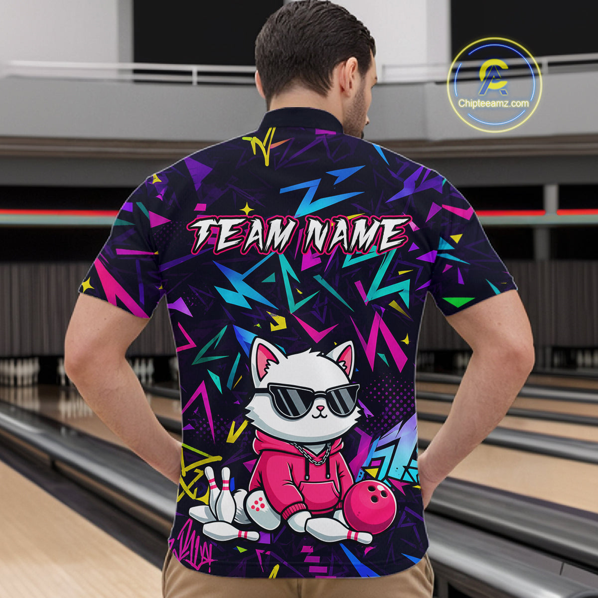 Man wearing a black bowling quarter zip with neon geometric patterns, custom team text, and a white cat mascot in sunglasses holding a pink bowling ball.