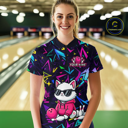 Woman wearing a black bowling quarter zip with neon geometric patterns, custom team text, and a white cat mascot in sunglasses holding a pink bowling ball.