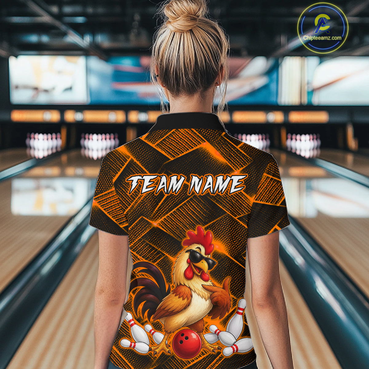 Woman wearing a orange and black bowling polo shirt featuring a cool rooster mascot wearing sunglasses, a red bowling ball, bowling pins, and custom team name text.