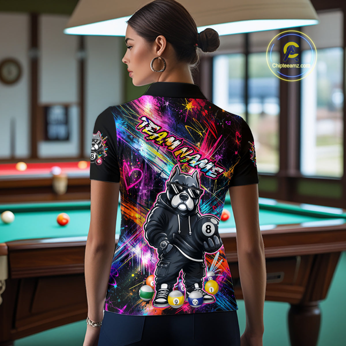 Woman wearing a vibrant graffiti-style billiards polo with a american bully dog, custom team name text, and colorful paint-streak graphics.