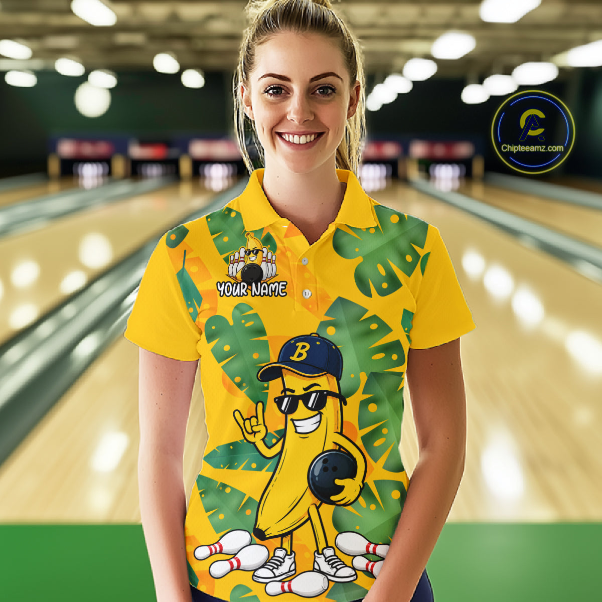 Woman in a bowling alley wearing a bright yellow tropical polo shirt with green leaf patterns, custom name text, and a smiling banana mascot holding a bowling ball.