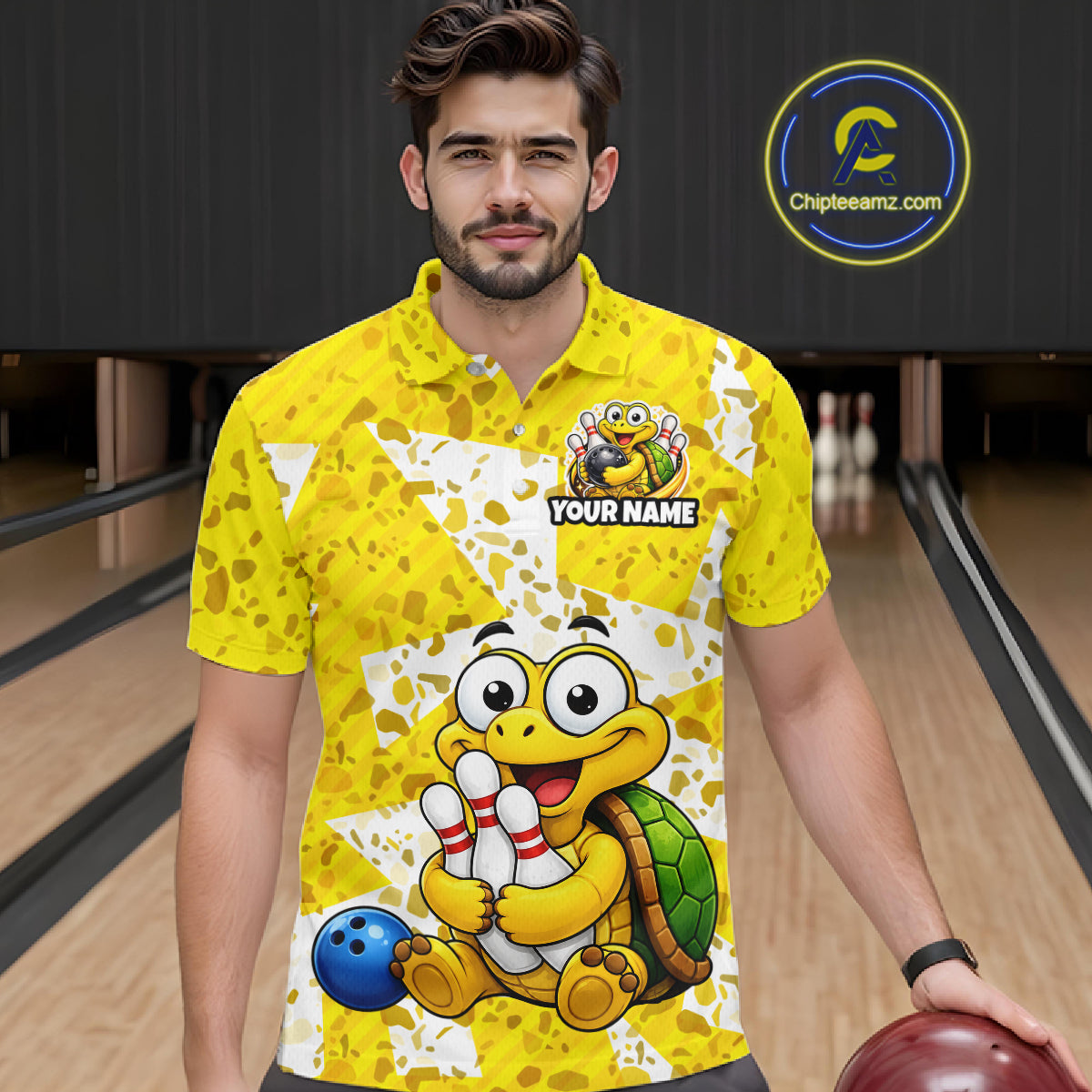 Man wearing a yellow bowling shirt with cartoon turtle design in a bowling alley.