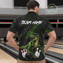 Load image into Gallery viewer, Man wearing bowling quarter zip shirt featuring a dinosaur standing among bowling pins and ball artwork on black green textured background.