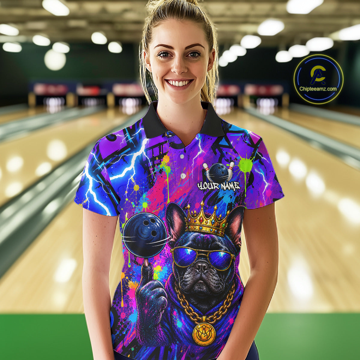 Women wearing personalized bowling polo shirt with a crowned bulldog holding a bowling ball, surrounded by paint effects and bold graphic patterns.