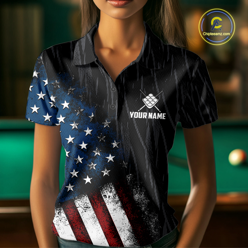 A woman wearing a black short-sleeve polo shirt with a distressed American flag print in blue, white, and red. The shirt features a white customizable logo on the left chest with the text 'YOUR NAME'.