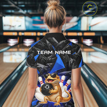 Load image into Gallery viewer, Women’s blue bearded dragon bowling polo shirt, back view on female model in bowling lane 