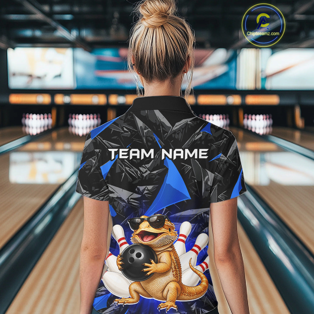 Women’s blue bearded dragon bowling quarter zip shirt, back view on female model in bowling lane 