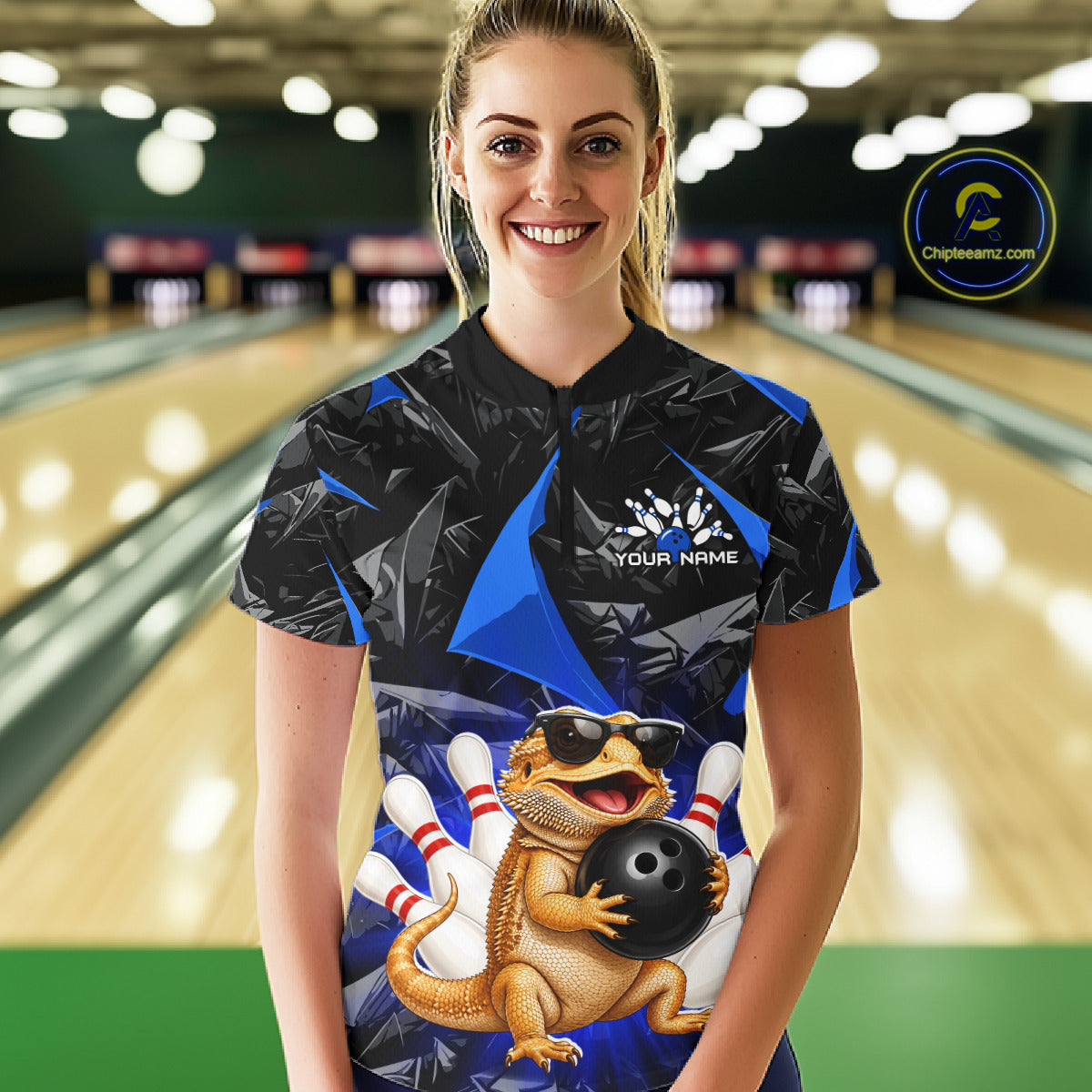 Women’s blue bearded dragon bowling quarter zip shirt, front view on female model in bowling lane 