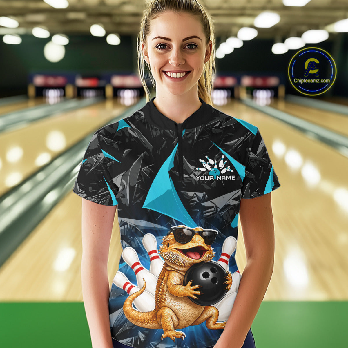 Women’s turquoise bearded dragon bowling quarter zip shirt, front view on female model in bowling lane 