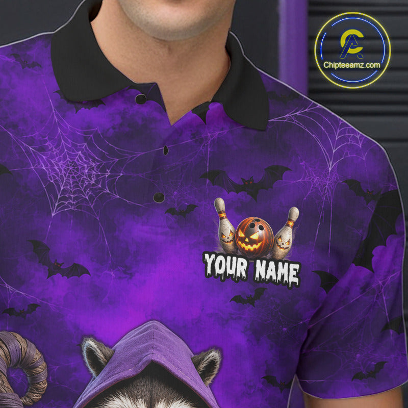 A close-up of a person wearing a purple Halloween-themed polo shirt with a black collar. The shirt features a spiderweb pattern, black bats, a jack-o'-lantern, bowling pins, and the text 'YOUR NAME' on the chest.