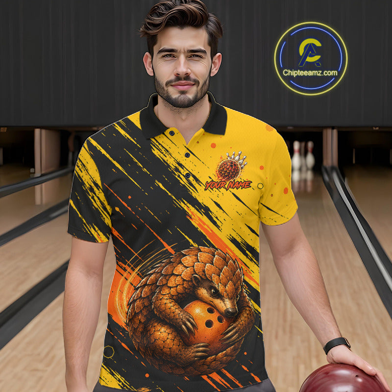 A man wearing a yellow and black bowling-themed graphic polo shirt with a pangolin and bowling ball design, standing in a bowling alley. A circular 'ChipteeAmz'