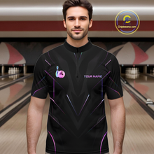 Load image into Gallery viewer, Man wearing a black bowling shirt with a logo and text in a bowling alley.