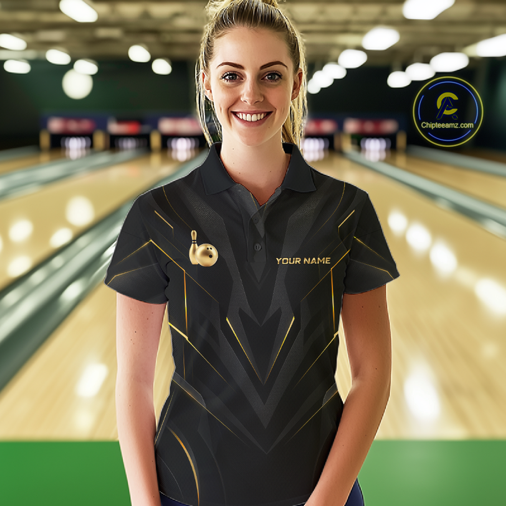 Woman wearing a black bowling shirt with gold accents in a bowling alley.