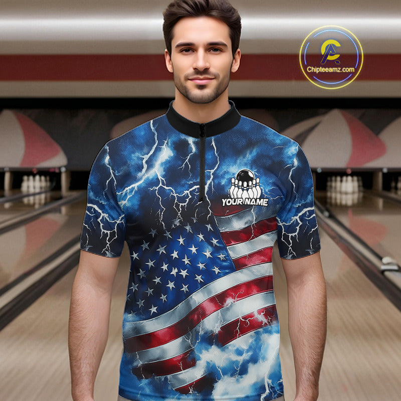 A man wearing a short-sleeve bowling shirt with a blue lightning and American flag print, standing in a bowling alley. The shirt features a black collar and a mock neck with a zipper, and the text 'YOUR NAME' is printed on the chest.