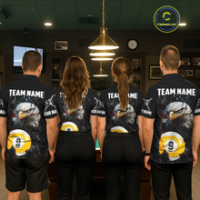 Load image into Gallery viewer, Four teammates in a billiards hall wearing matching black eagle-themed pool polos with cracked flag artwork, sleeve name text, and large 9-ball graphics.