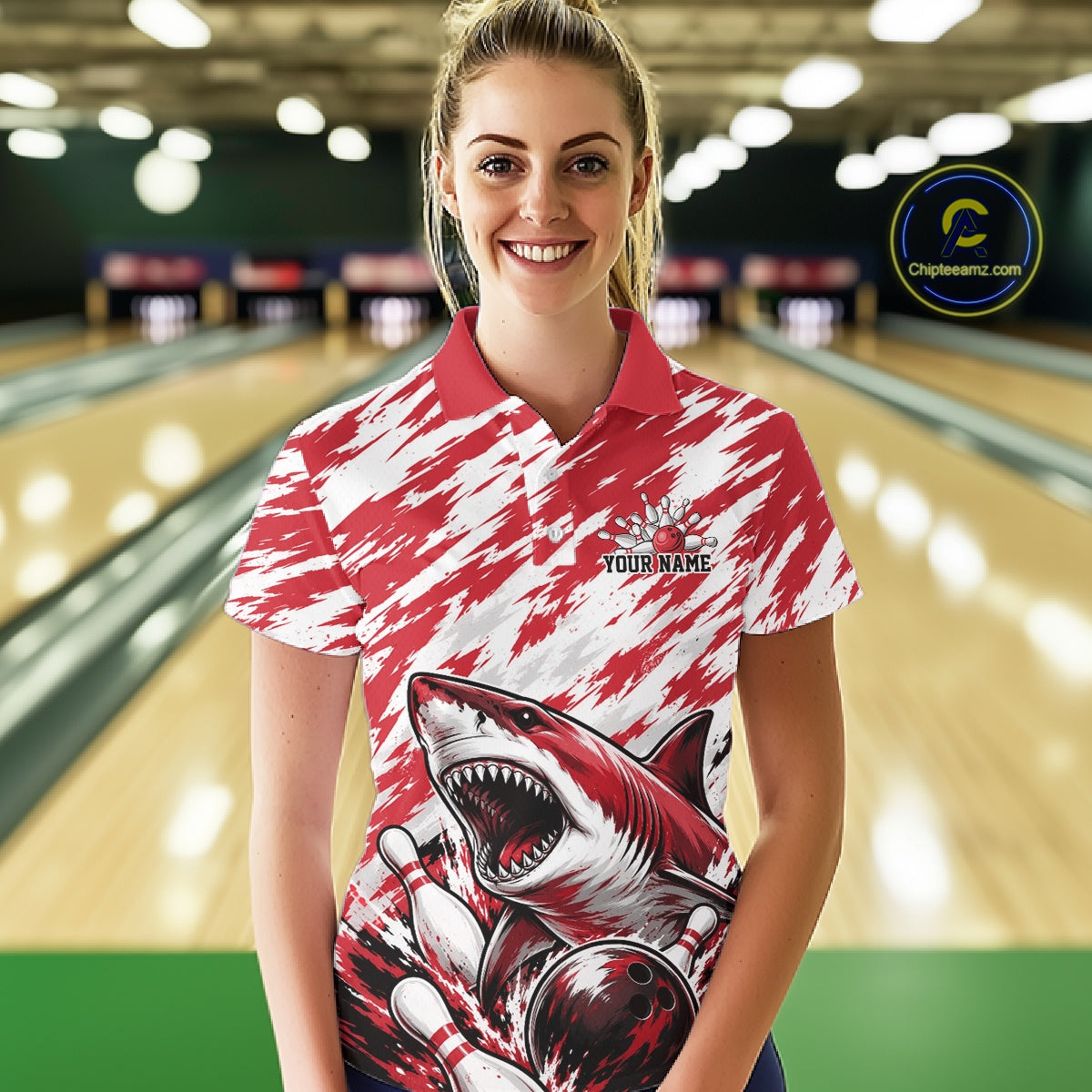 Woman wearing a red and white polo shirt with a shark design in a bowling alley.
