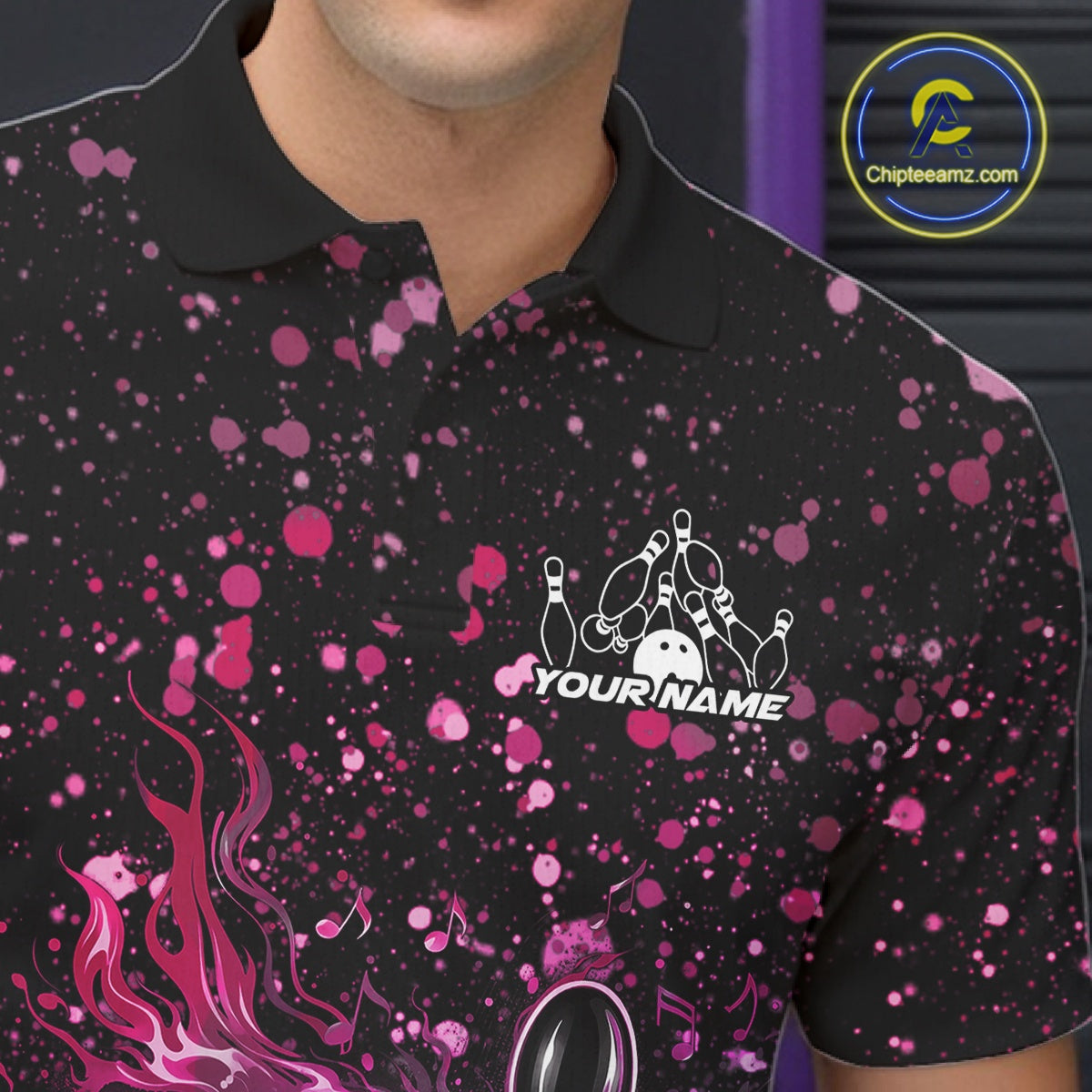 Left chest close-up of a black bowling polo shirt featuring flaming bowling artwork with pink and purple paint splatter details.