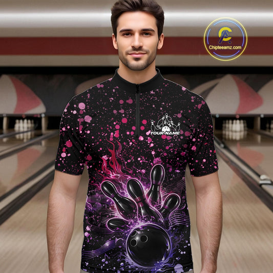 Male model wearing a black bowling quarter-zip shirt at the lane with flaming bowling strike artwork and pink-purple music-themed splatters.