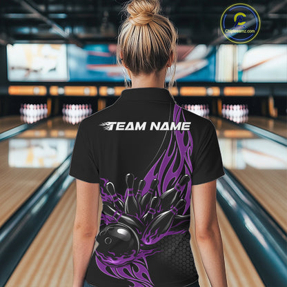 Female model back view in a bowling lane wearing a black polo shirt featuring a purple flaming black bowling ball striking pins in bold motion artwork.