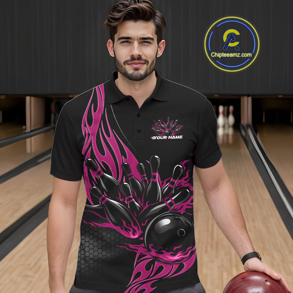 Male model seen from the front in a bowling lane wearing a black polo shirt featuring a pink flaming black bowling ball striking pins in a dynamic action scene.