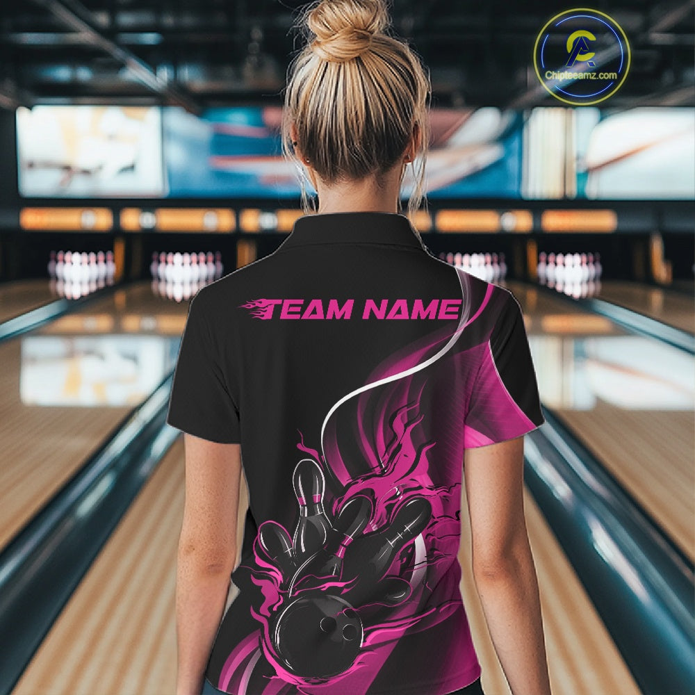 Female model back view in bowling center wearing black and pink polo shirt showcasing flame bowling ball striking pins in vivid motion artwork.