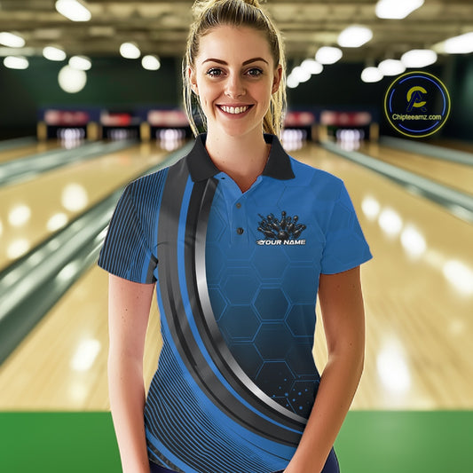 Female model in a bowling lane wearing a black and blue polo shirt with honeycomb texture and a flaming bowling strike graphic.