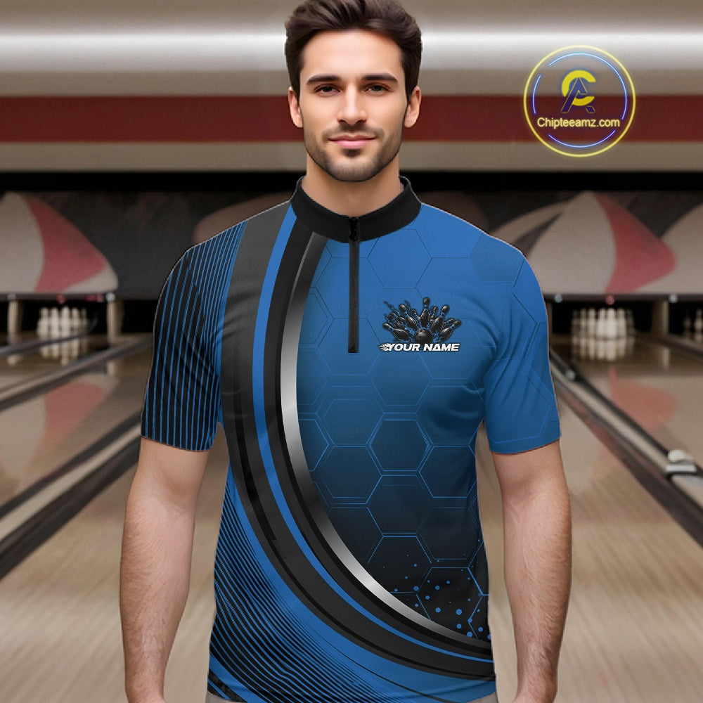 Male model in a bowling lane wearing a black and blue quarter zip shirt with honeycomb graphics and a flaming bowling ball striking pins.