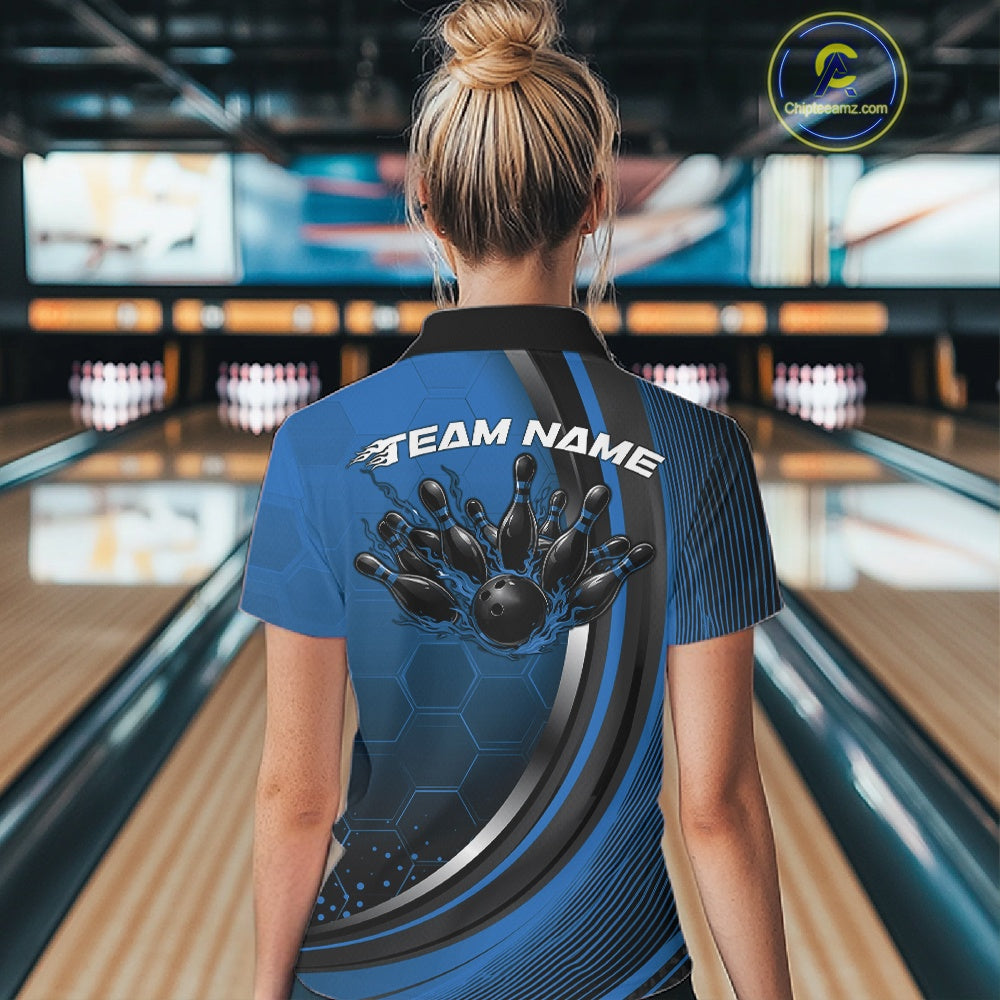 Back view of a women s black and blue bowling quarter zip with honeycomb pattern and flame bowling ball striking pins graphics in a bowling alley.