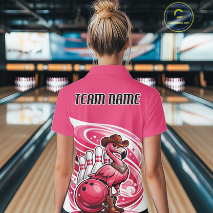 Back view of a female model in a bowling venue wearing a pink polo shirt featuring a cowboy flamingo leaning on a bowling ball.