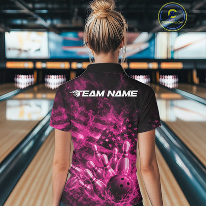 Back view of a womens black and pink bowling polo displaying a flaming bowling strike scene with flag-inspired details.