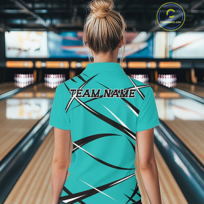 Back view of a female bowler wearing a turquoise blue, black, and white bowling polo shirt in a bowling lane