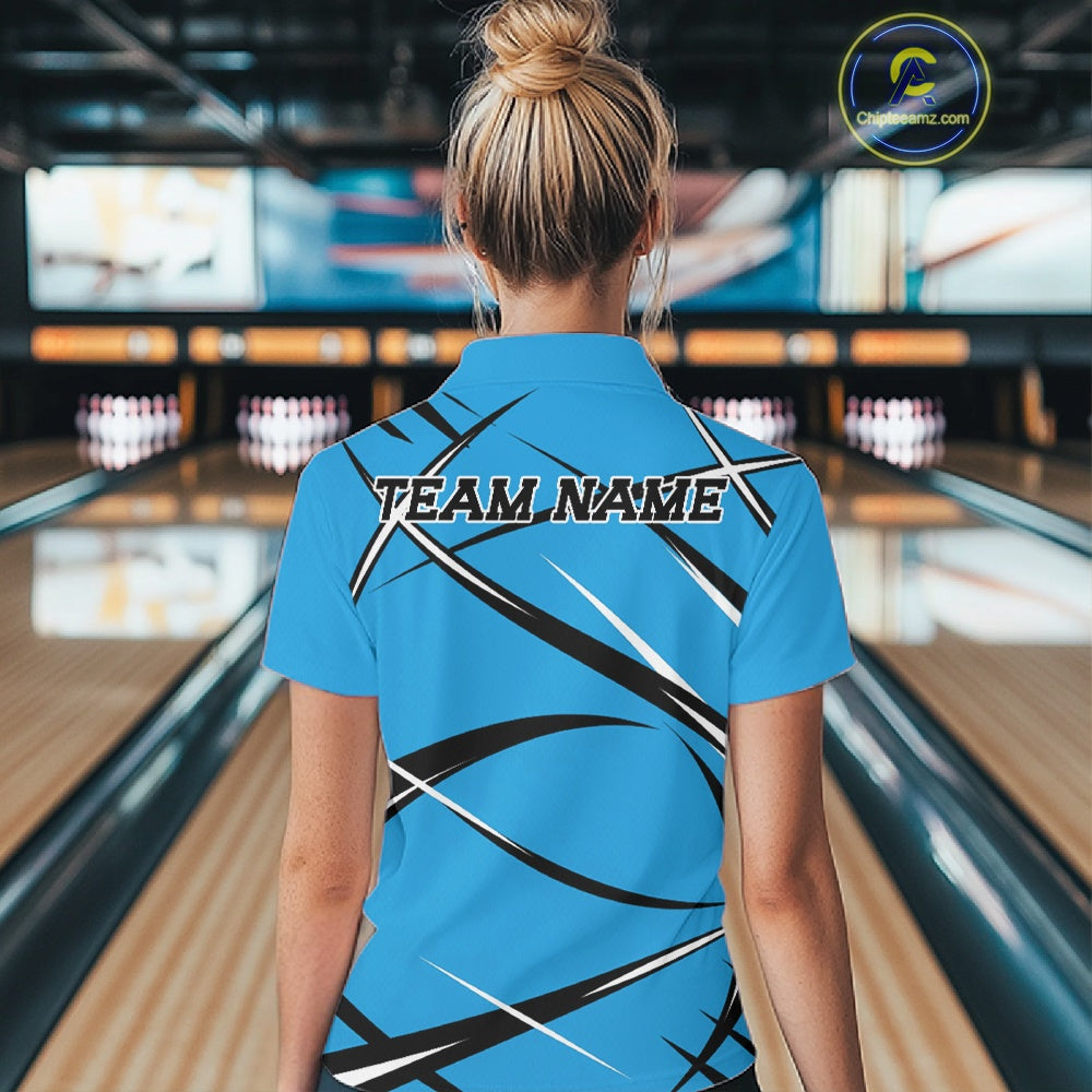 Back view of a female bowler in a bowling lane wearing a blue, black, and white bowling quarter zip shirt