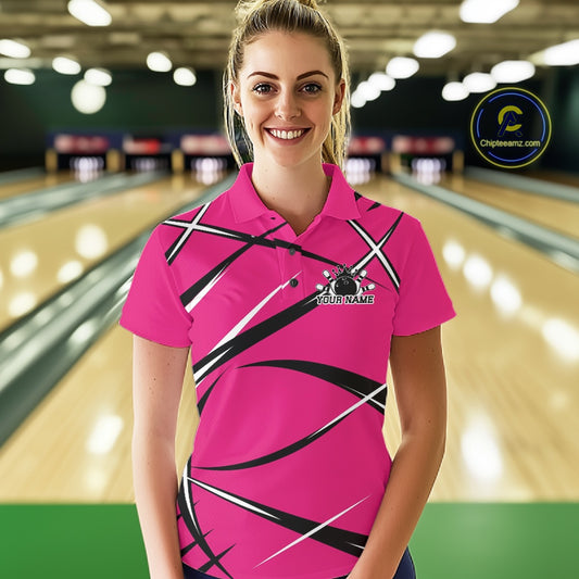 Front view of a female bowler in a bowling alley wearing a pink, black, and white bowling polo shirt with a sporty jersey design