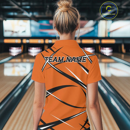 Back view of a female model wearing an orange, black, and white bowling polo shirt in a bowling lane