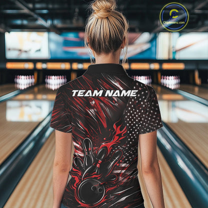 Female model at a bowling lane, back view of black and red quarter zip shirt showcasing patriotic flames bowling ball striking pins with flag-themed accents