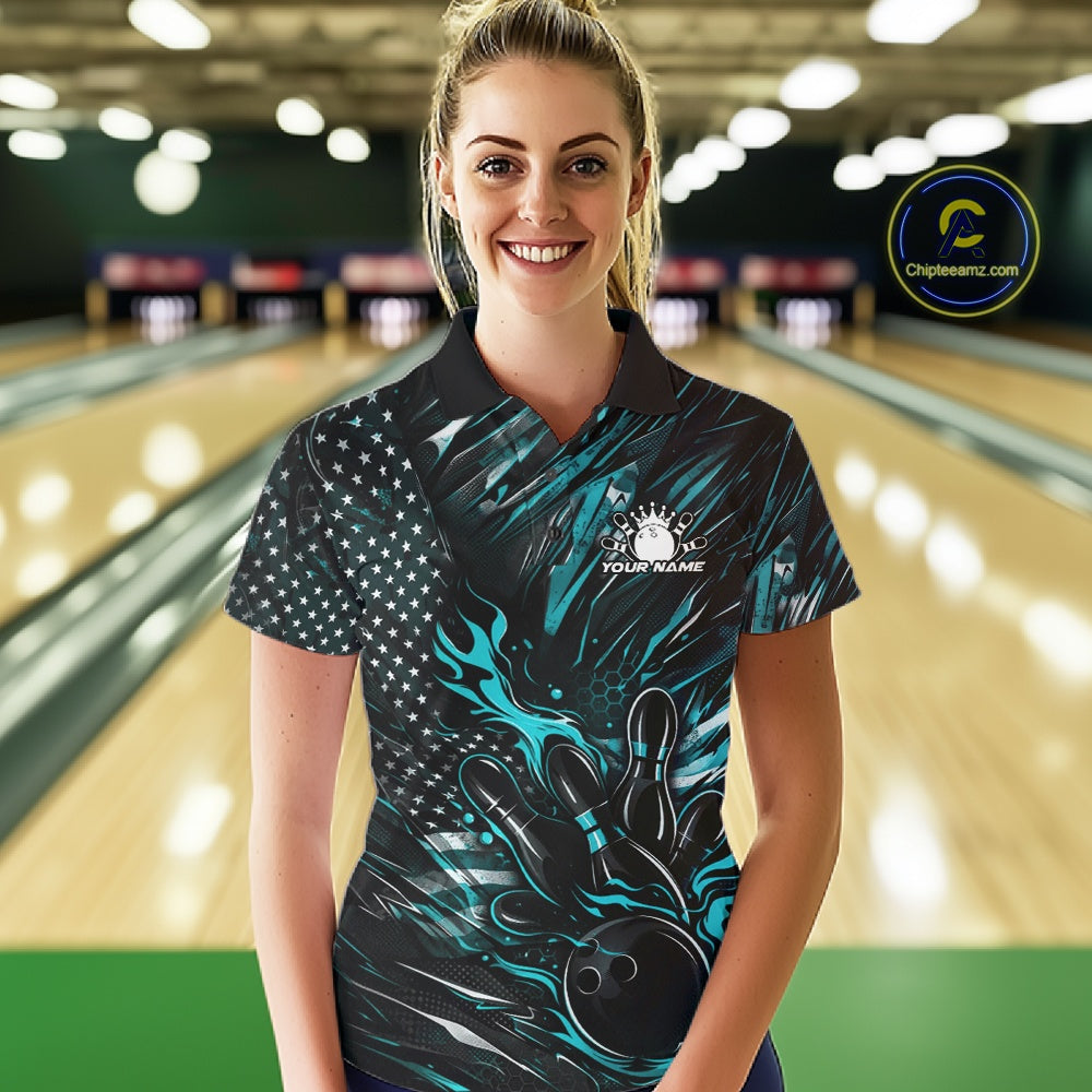 Female model at a bowling lane wearing a black and turquoise blue bowling polo shirt with patriotic bowling strike artwork and vibrant graphics.