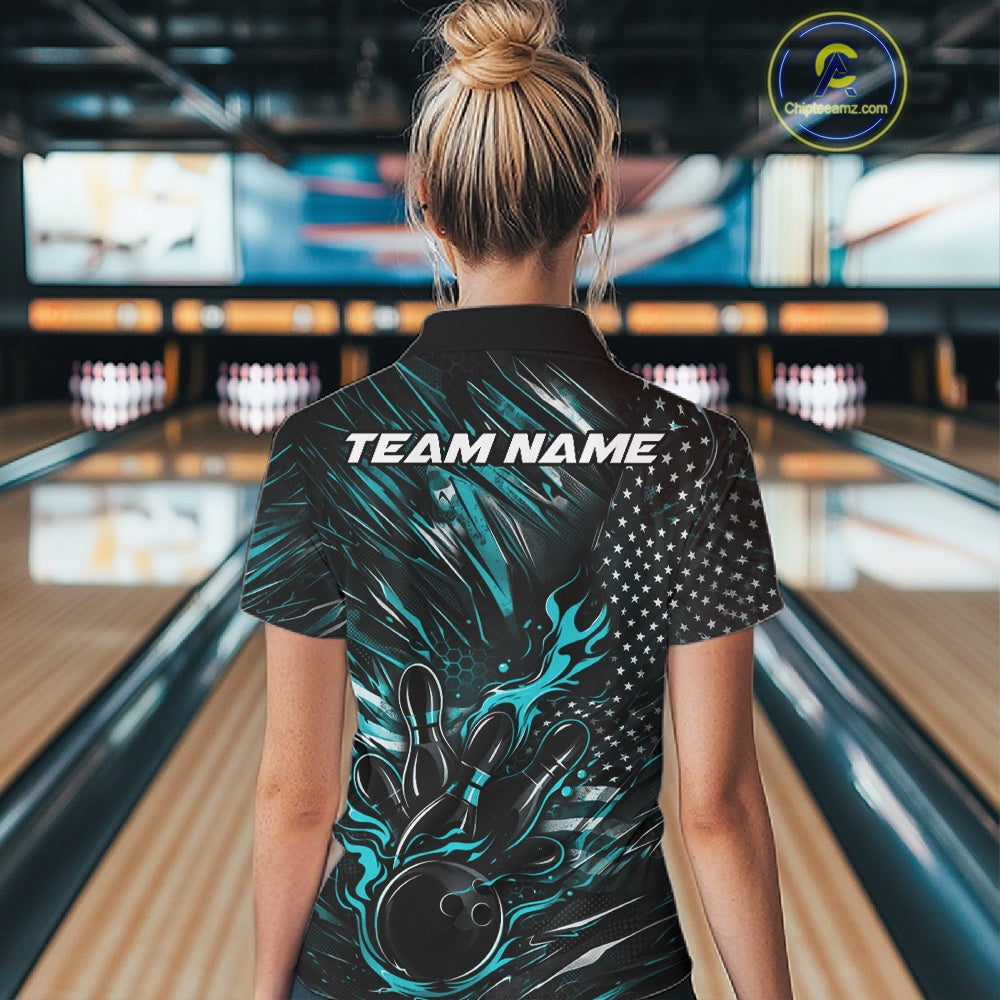 Back view of a female model in a bowling alley wearing a black and turquoise blue polo shirt featuring a flaming bowling ball and patriotic bowling motif.