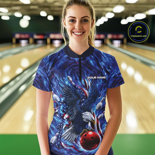 Front view of a female model in a bowling lane wearing a quarter zip shirt with eagle motif around a bowling ball, flag details, and pins.