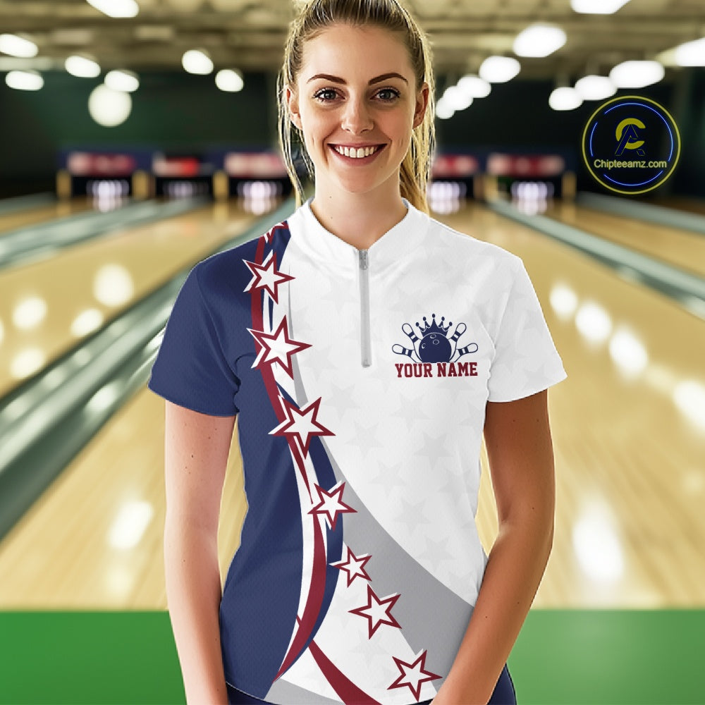 Female model front view at the bowling lane wearing a red, white, and blue bowling quarter zip shirt with bowling artwork and stars.