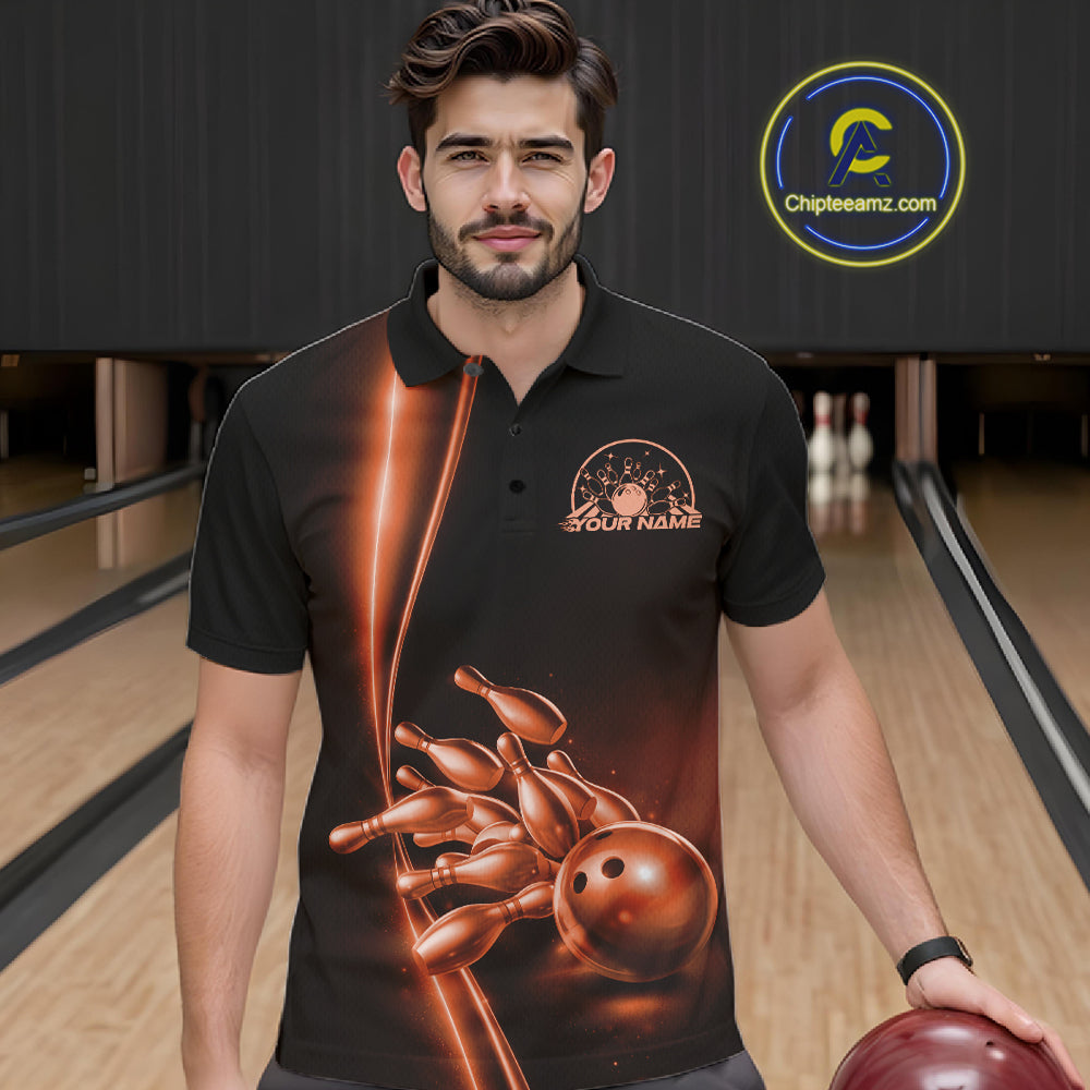 In bowling lane front view male model wearing bowling polo shirt, black base with orange bowling ball and pins graphic, energetic sports lighting
