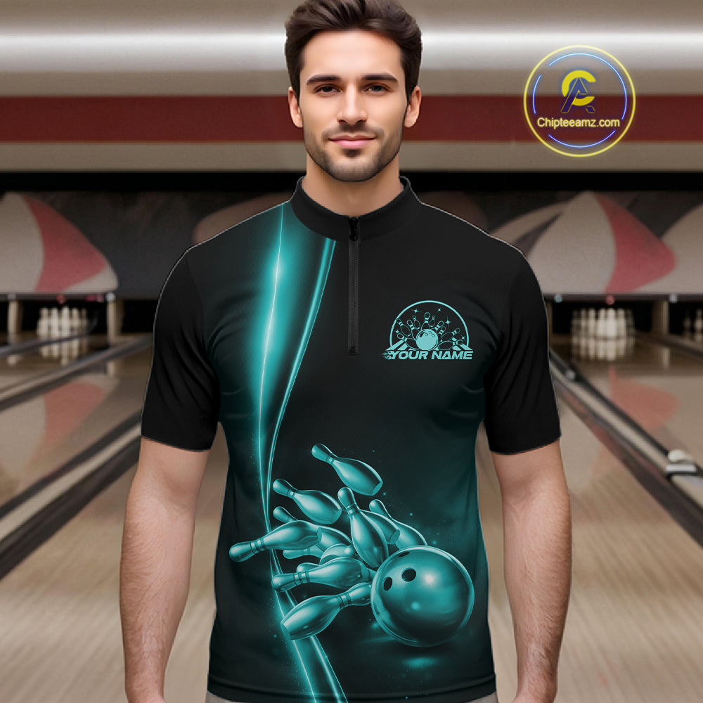 Front view of a male model in a bowling lane wearing a black quarter-zip shirt with turquoise blue bowling ball and pins design and sporty bowling visuals.