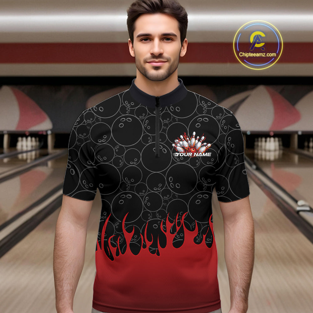 Male model at a bowling lane wearing a black quarter zip shirt, front view showing bowling ball pattern with red flames rising and energetic bowling-themed illustration