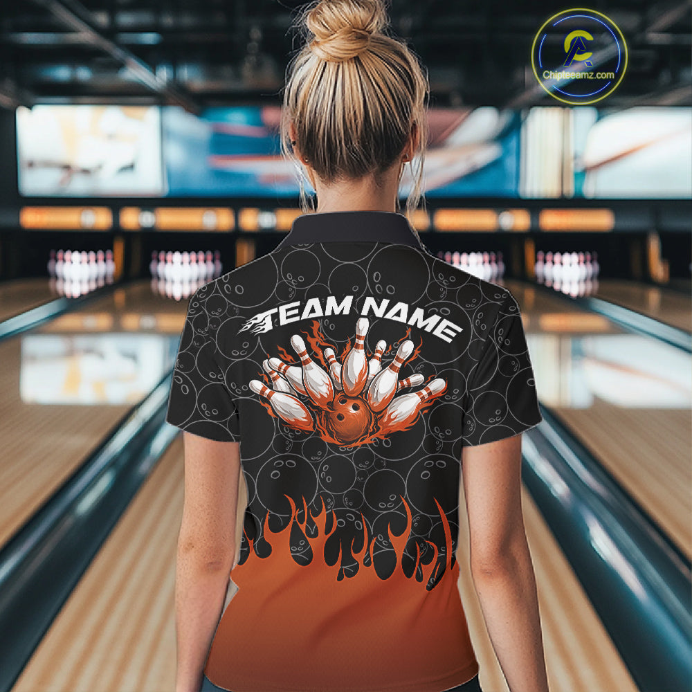 Back view of a female model in a bowling lane wearing a black quarter-zip shirt, featuring vibrant orange flames rising with bowling ball pattern and dynamic bowling action graphics.