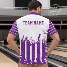 Load image into Gallery viewer, Male model showcasing the back design of a custom purple and white patriotic stars and stripes men's bowling polo shirt with a customizable "TEAM NAME" text template inside a bowling alley.