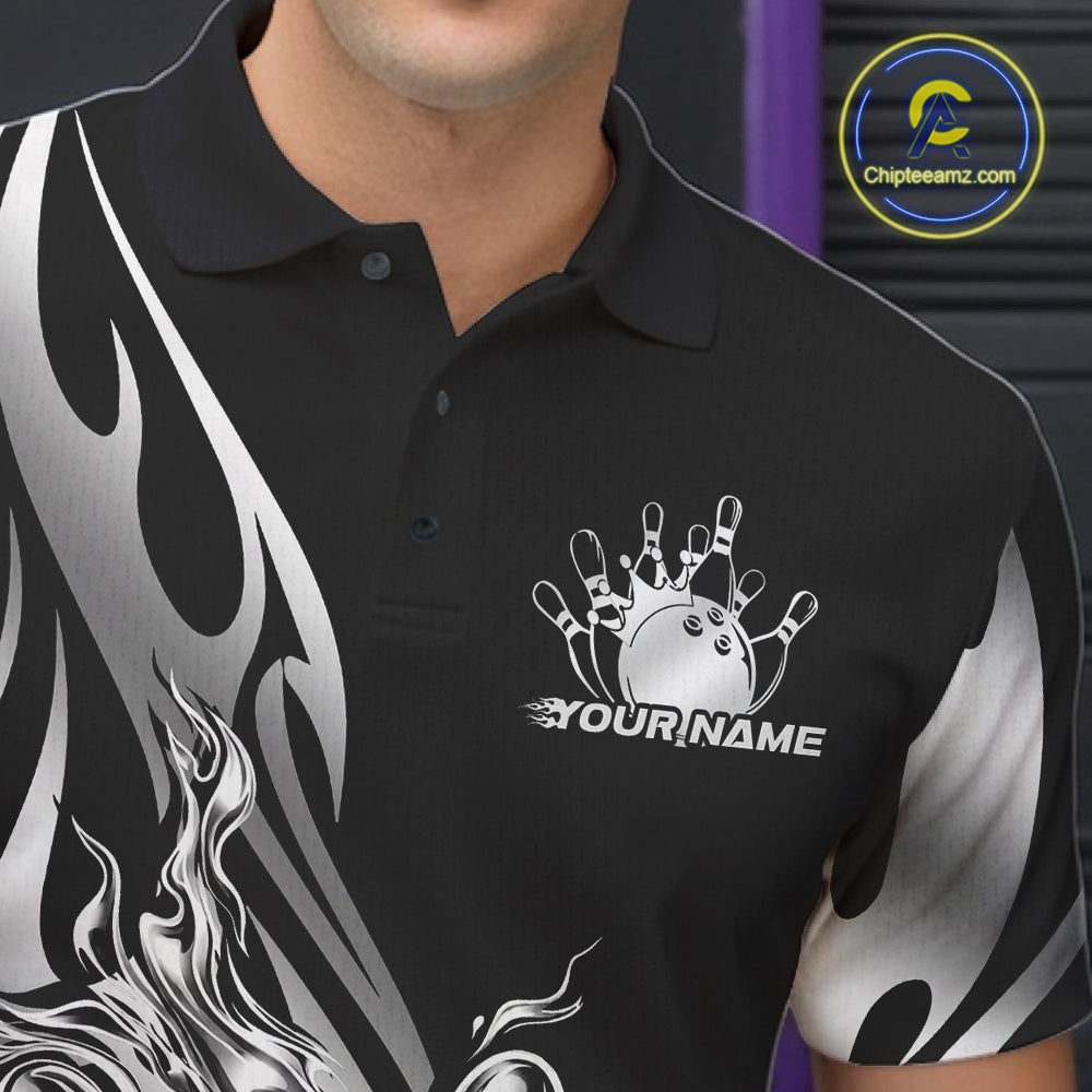 Close-up view of the left chest area of a black polo shirt showing a silver metal tribal flame bowling ball and pins design detail.